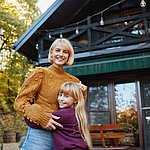 Mutter und Tochter umarmen sich vor der H&uuml;tte